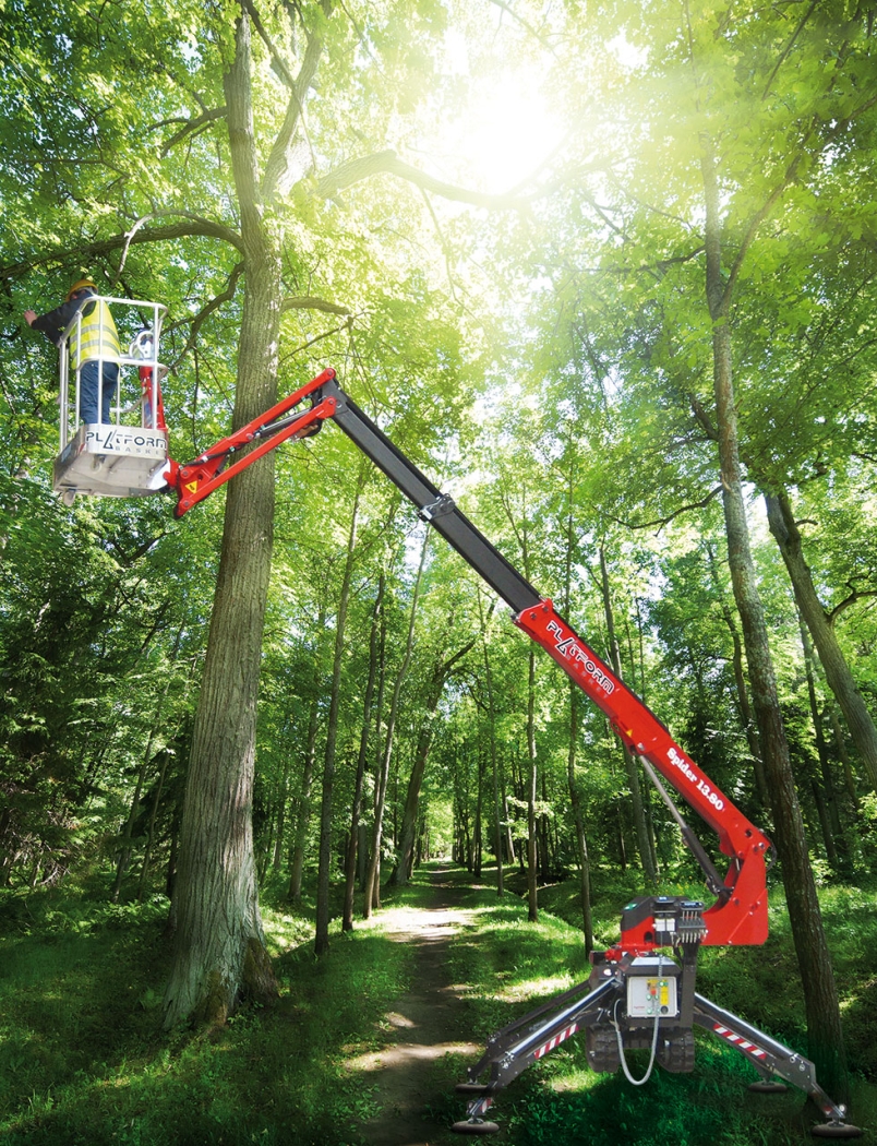 Spider 13.80 aerial lift extended in a forest setting for tree maintenance.