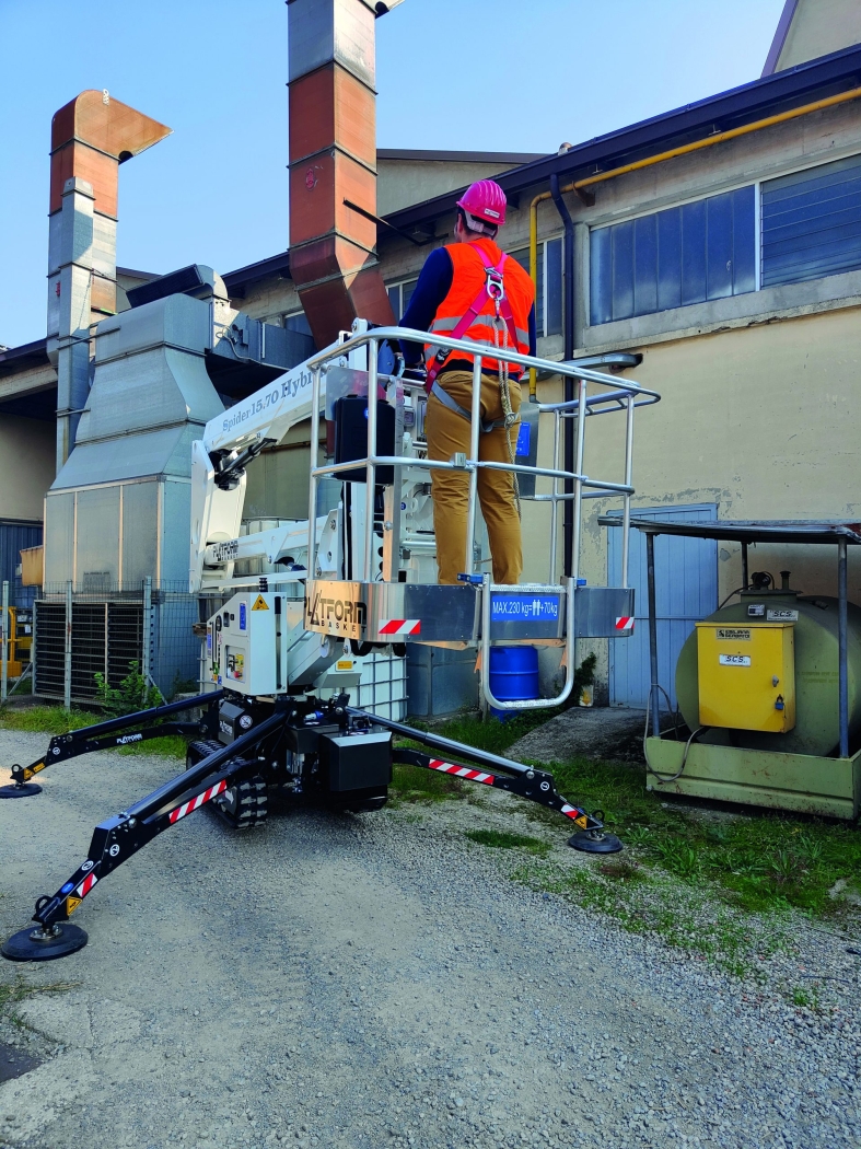 Spider 15.70 boom lift extended for maintenance work on industrial equipment.