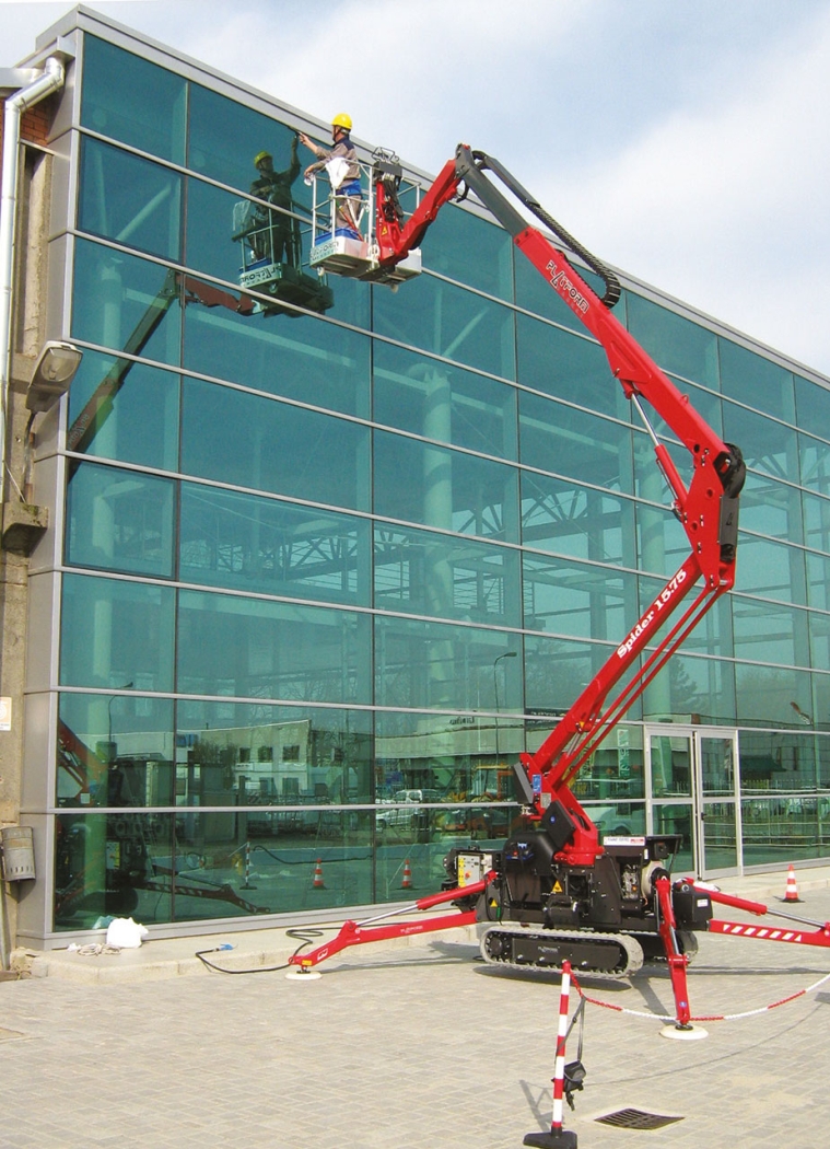 Spider 15.75 boom lift extended for glass building maintenance.