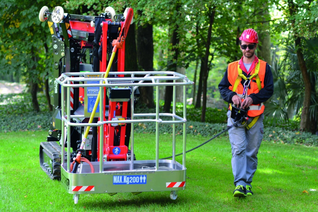 Spider lift with a worker in a green outdoor setting