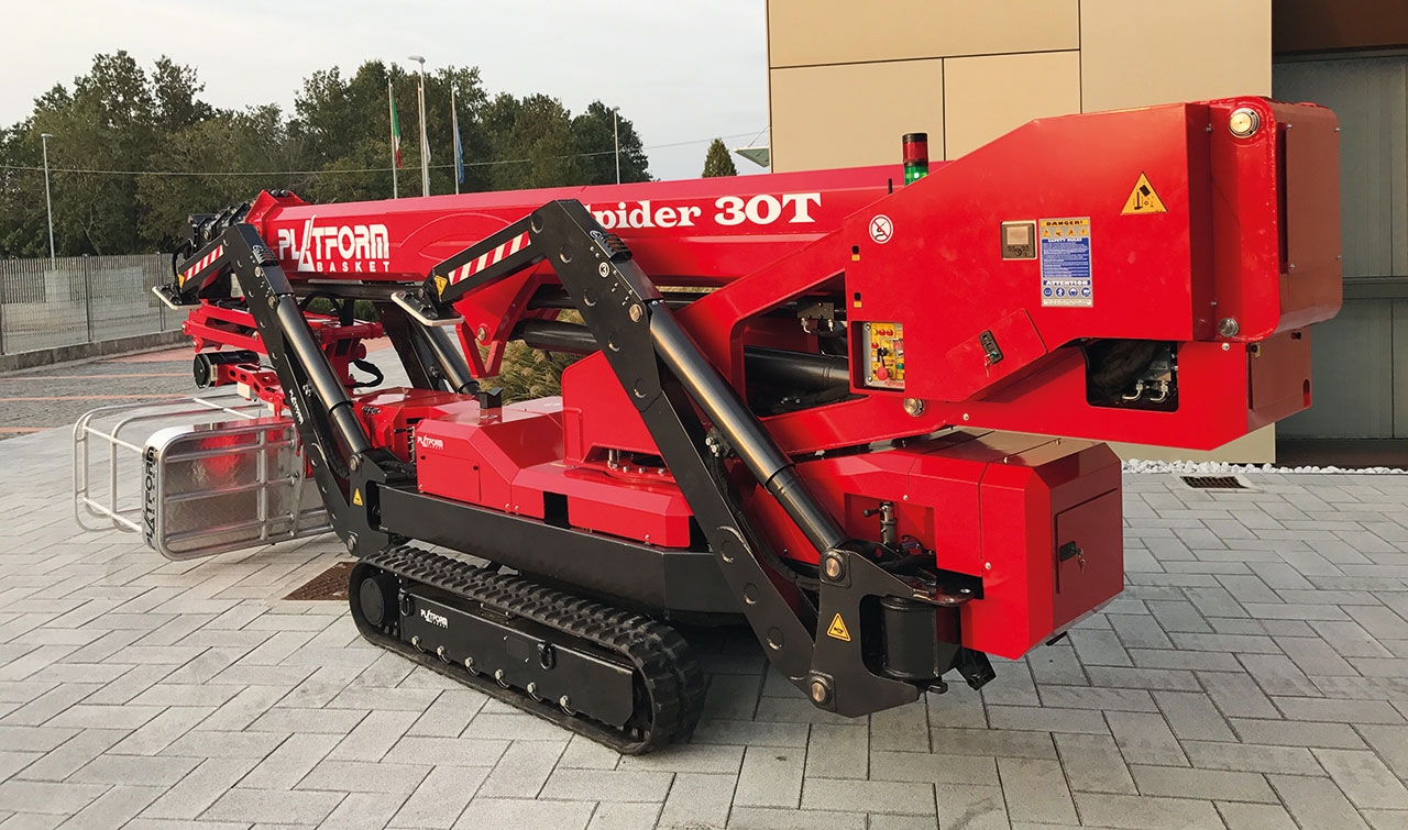 Spider lift in a compact position on a paved surface.