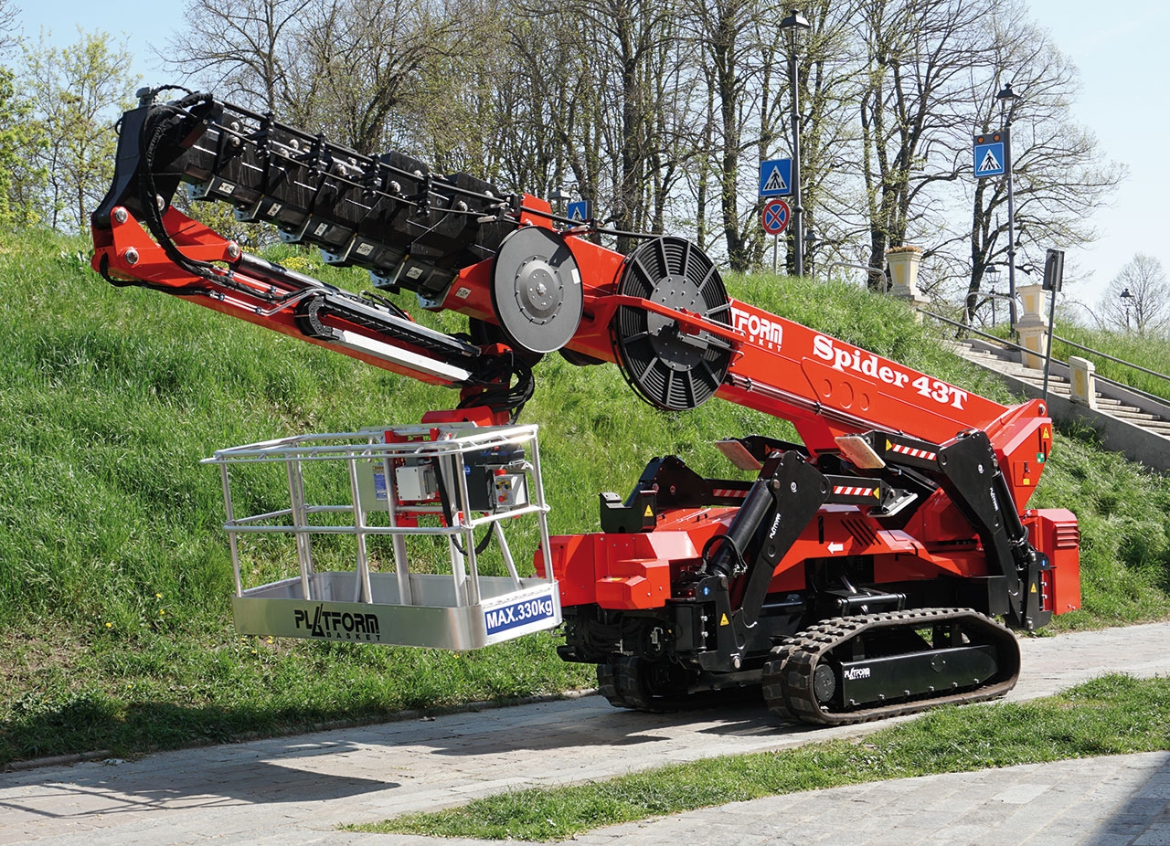 All-terrain lift operating on a sloped green landscape.