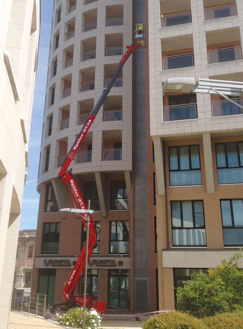 Spider lift extended outside a multi-story building.